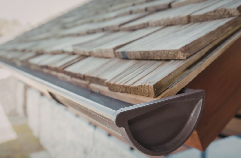 Strive Roofing & Construction team member installing gutters in Spring, TX highlighting protection and local expertise